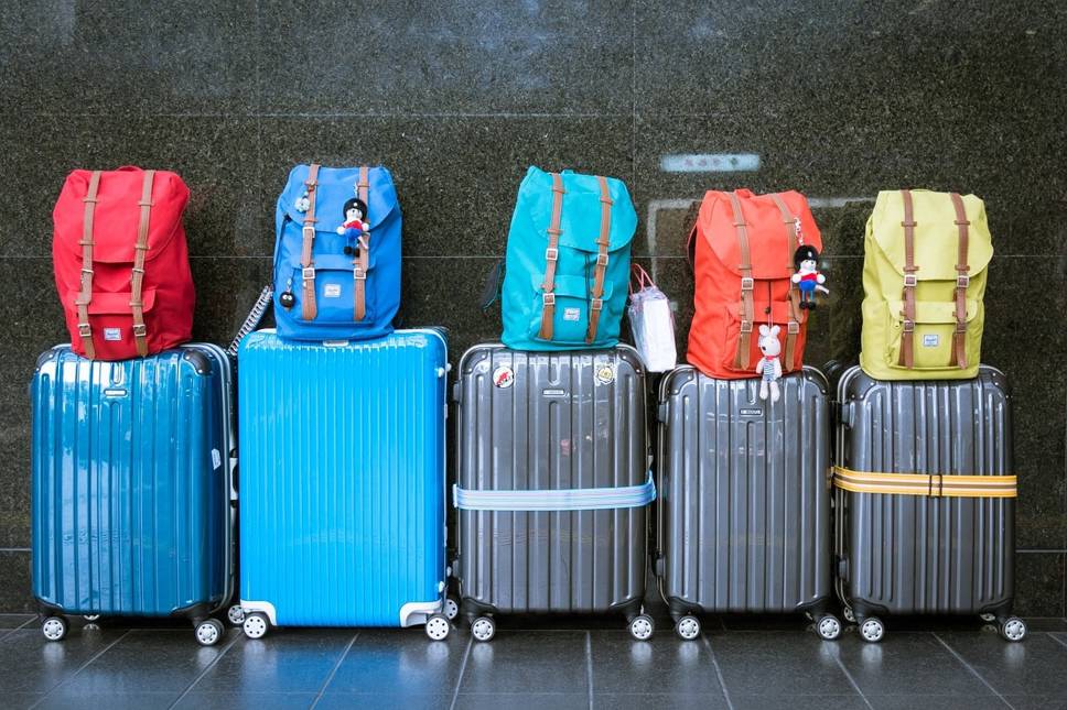 Row of suitcases with backpacks on top